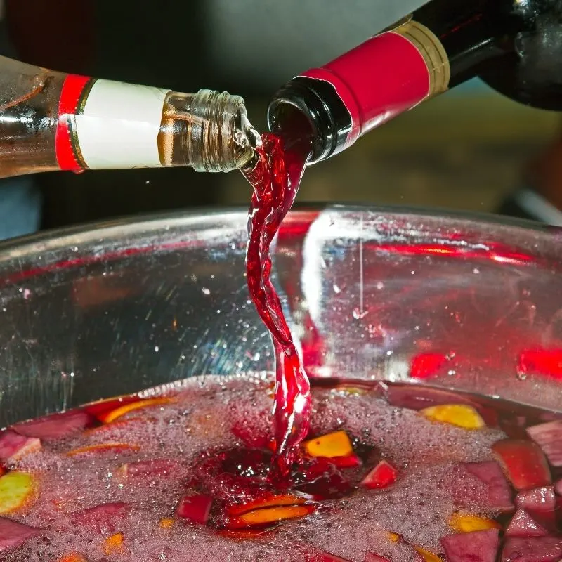 making spanish sangria  in a big bowl. The Perfect Drink for a Spanish Themed Party
