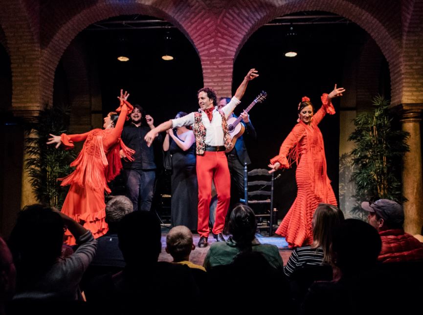 three flamenco dancers on stage at the Flamenco Show Alegría while people are watching, Seville in June