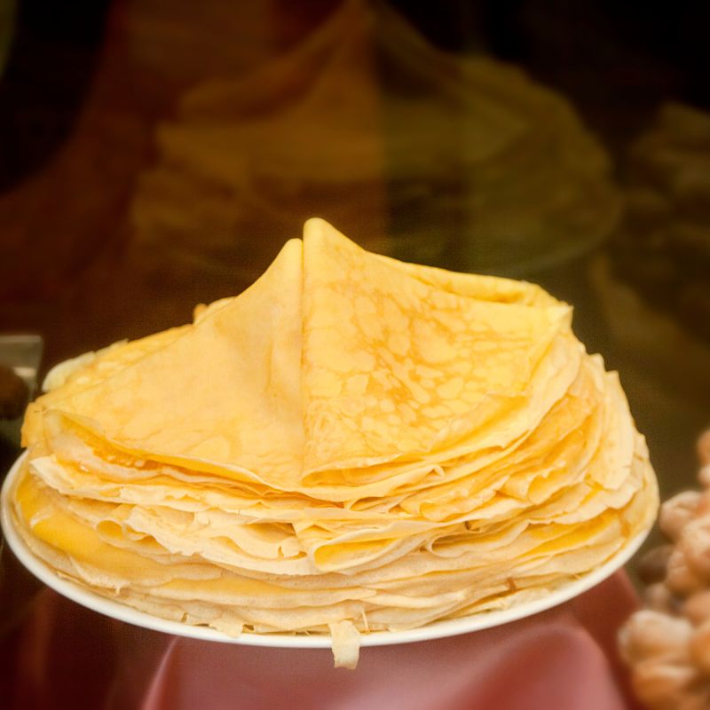 Spanish style crepes staked on a white plate for spanish breakfast. 