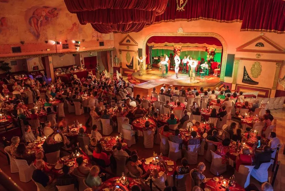 Tablao Flamenco El Palacio Andaluz, a stage with dancers on a hall filled with audiences sitting together by table