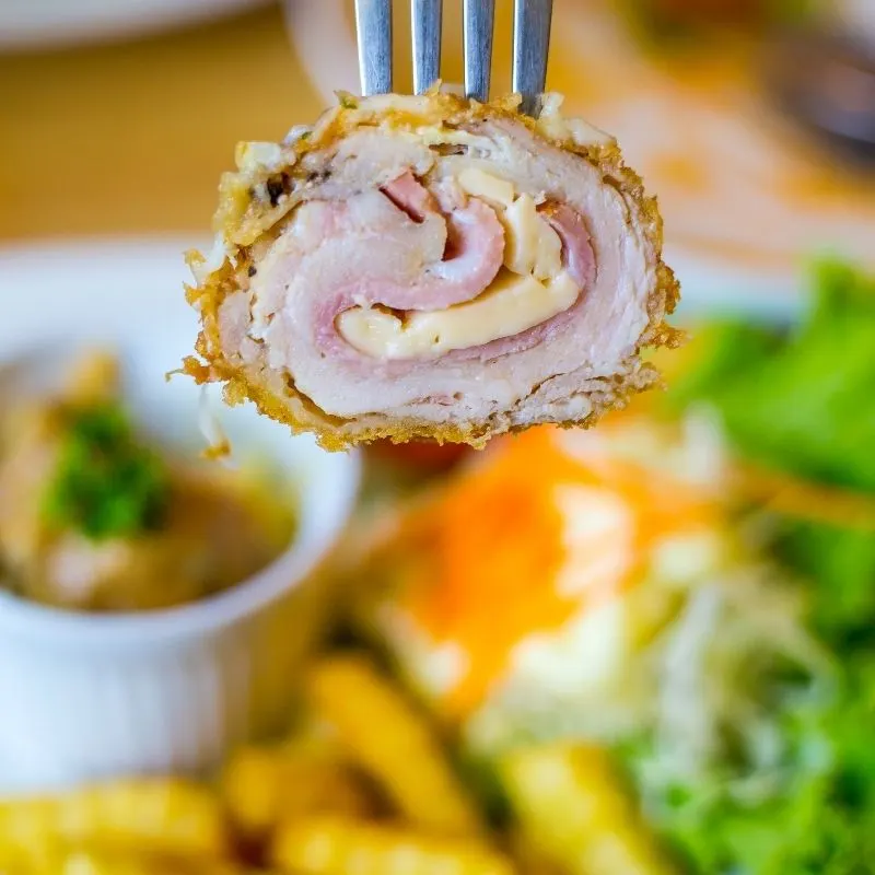 closeup with a Fried Flamenquines Cordobeses bite in a fork.