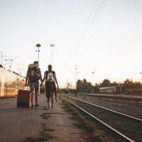a couple walking by the train track for their travel from Granada to Malaga