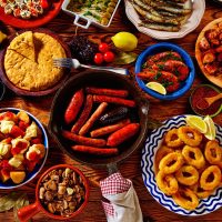 various spanish tapas plates on a wooden table.
