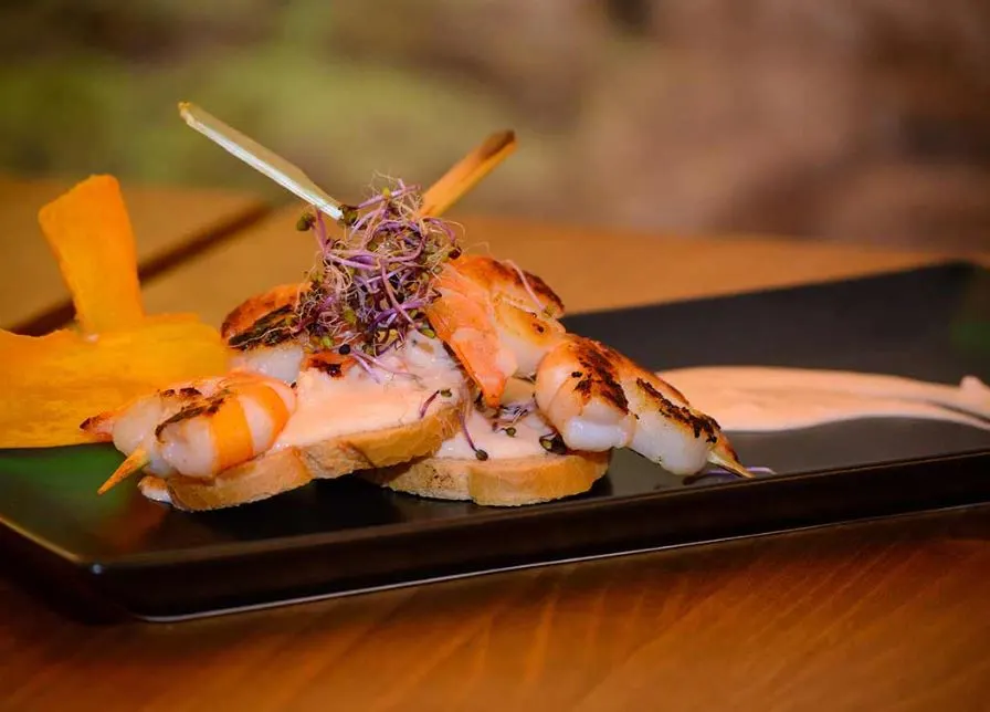 Pelayo Bar de Tapas, a closeup of shrimp tapas on a black platter on a table