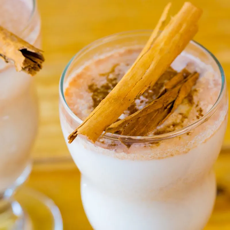 spanish eggnog in two glasses, decorated with cinnamon sticks 