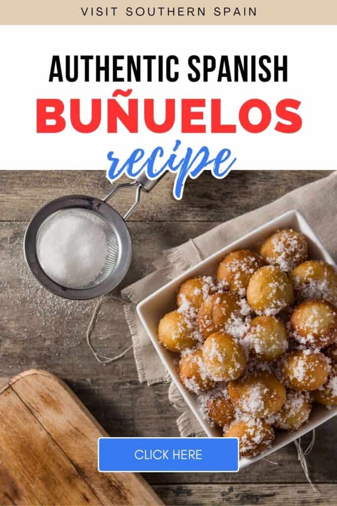 A flatlay of bunuelos are seen. They are grouped together in a square container. On its side is a sifter with some powdered sugar in it.