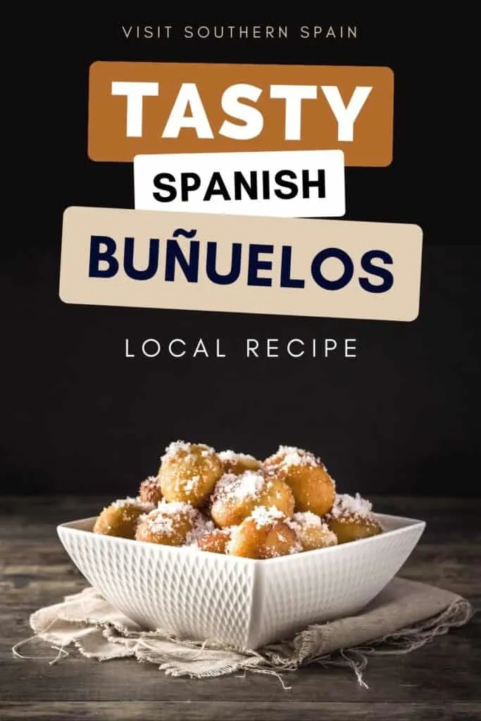 Bunuelos can be seeen in a square container. The container is on a table with cloth.