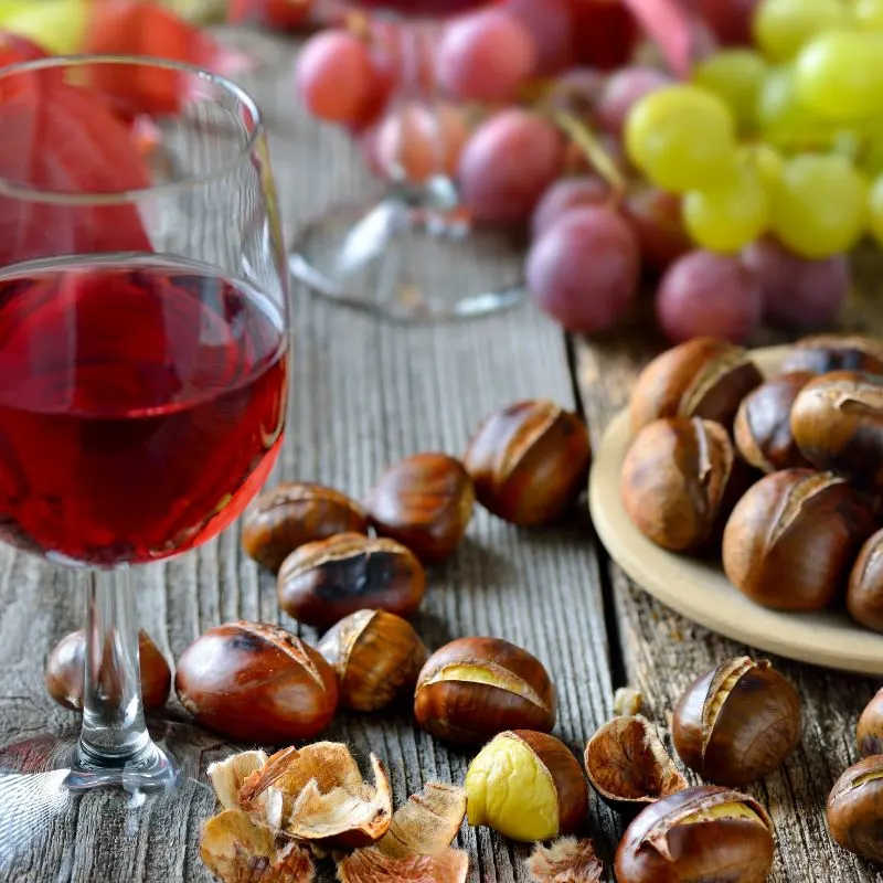 chestnuts and wine on a wooden table that can be eaten during Malaga in Winter