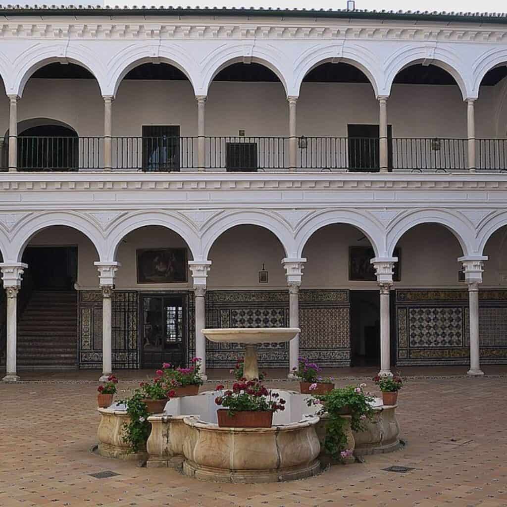 a courtyard with many arches and a fountain without water in it