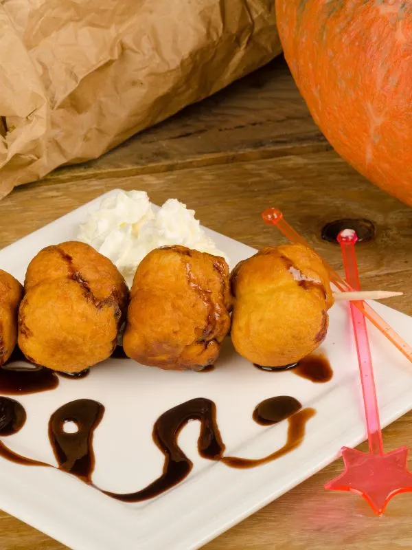 best pumpkin desserts served with whipped cream, chocolate sauce on a white plate next to a pumpkin