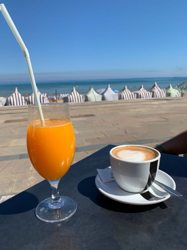 coffee and orange juice on a table with sea view.