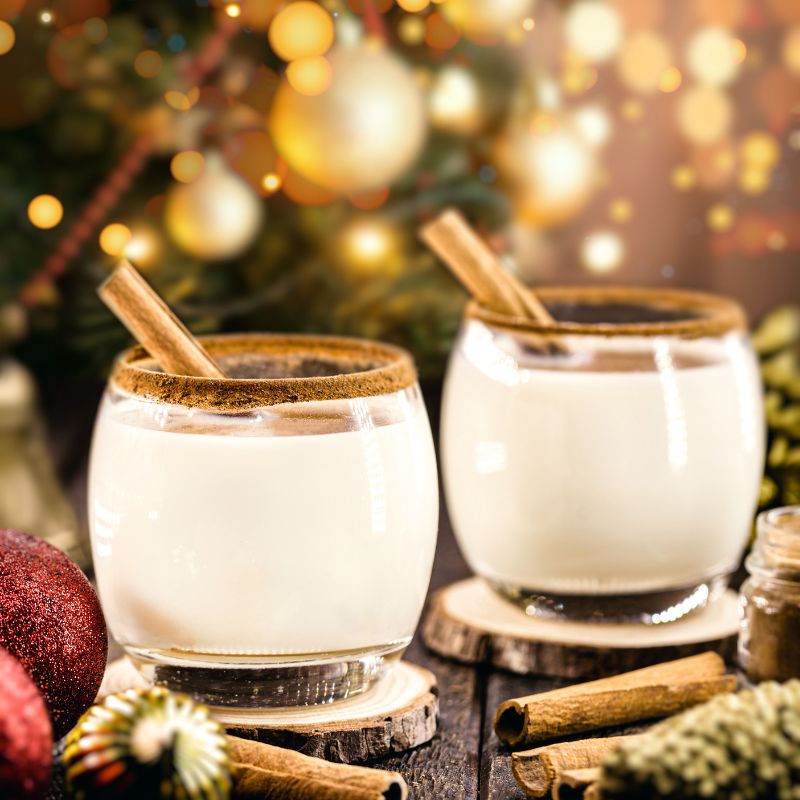 coquito drink in two glasses, decorated with two sticks of cinnamon, on a wooden table with a festive background.
Best Coquito Recipe for the Holidays