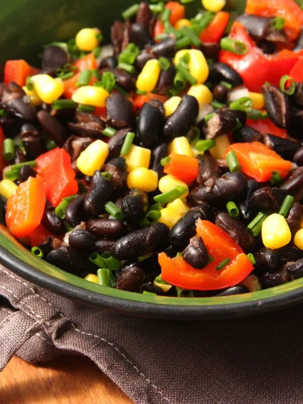 a closeup of a black bean salad on a green bowl
