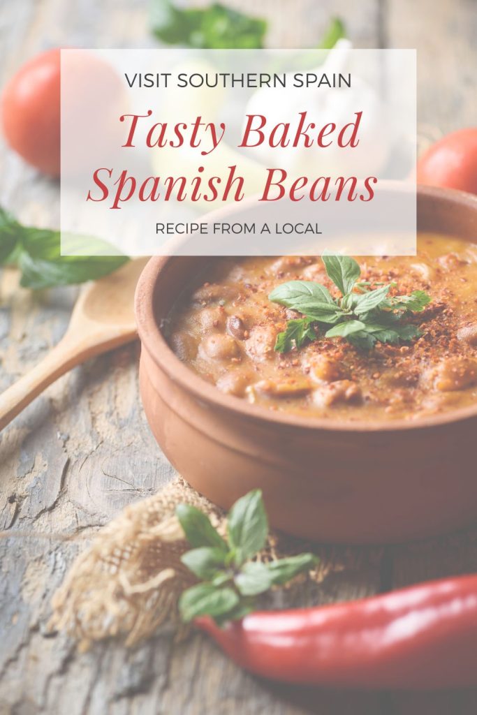 A bowl of baked beans next to tomatoes and peppers. On top it#s written tasty baked spanish beans.