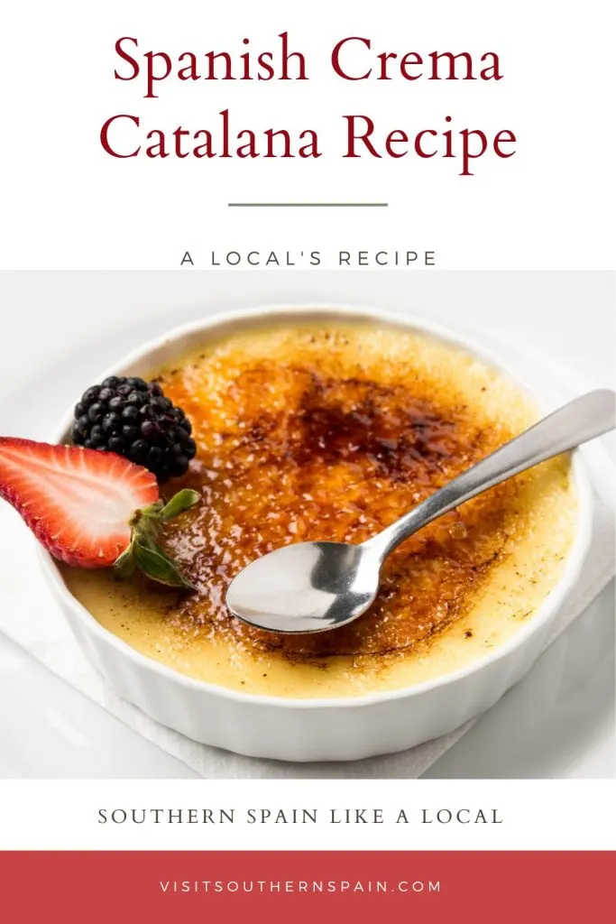 A bowl with crema catalana decorated with berries, on a white surface. On top it's written spanish crema catalana recipe.