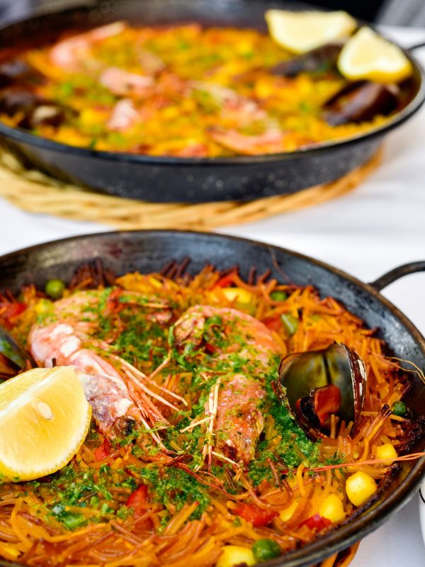 2 pans or paella with pasta ready to be served.