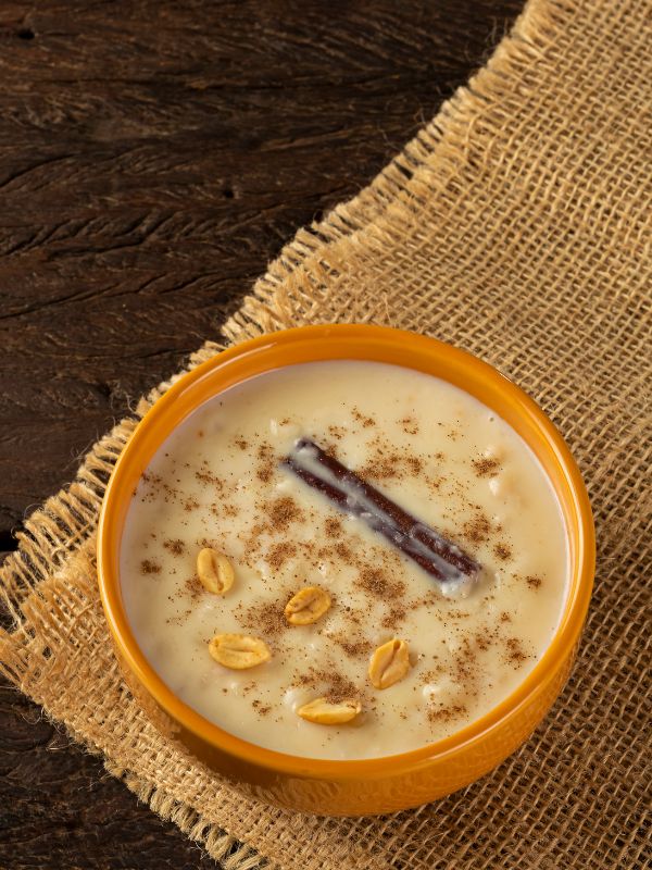 Spanish almond soup decorated with cinnamon and peanuts, on a wooden table.