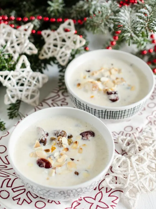 Spanish almond soup in 2 bowls and in the background there are Christmas decorations.