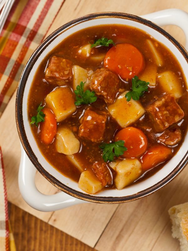 Spanish beef stew with potatoes in a pot on a wooden table