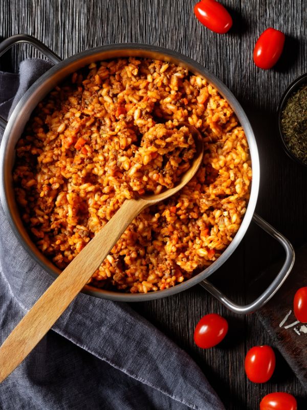 Spanish rice with ground beef in a pot, on a dark surface