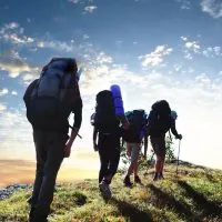 a group of people with backpacks hiking on a trail.