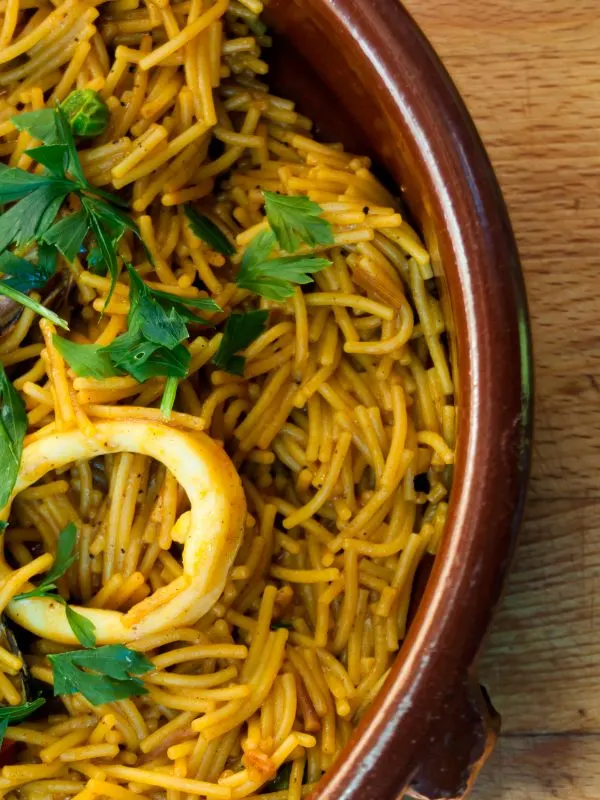 closeup with paella with pasta in a clay bowl