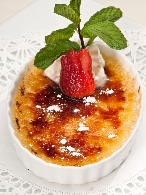 crema catalana decorated with cream, strawberry and mint.