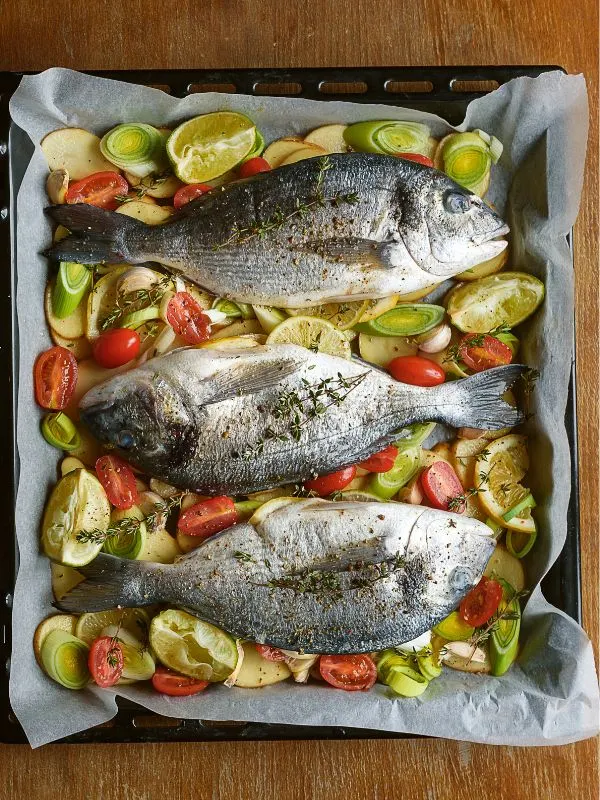 spanish fish recipe on a tray ready to be put in the oven