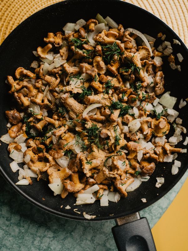 spanish garlic mushrooms with onions in a pan.