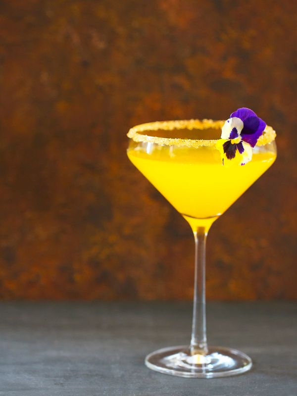 Agua de Valencia drink in a tall glass decorated with a pansy. 30 Most Famous Spanish Drinks