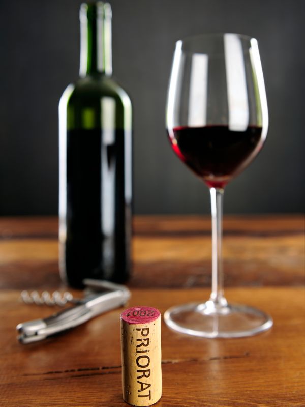 Priorat cork, a glass of red wine and o bottle in the background. 30 Most Famous Spanish Drinks