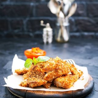 Spanish fried fish on a wooden plate on a kitchen counter.