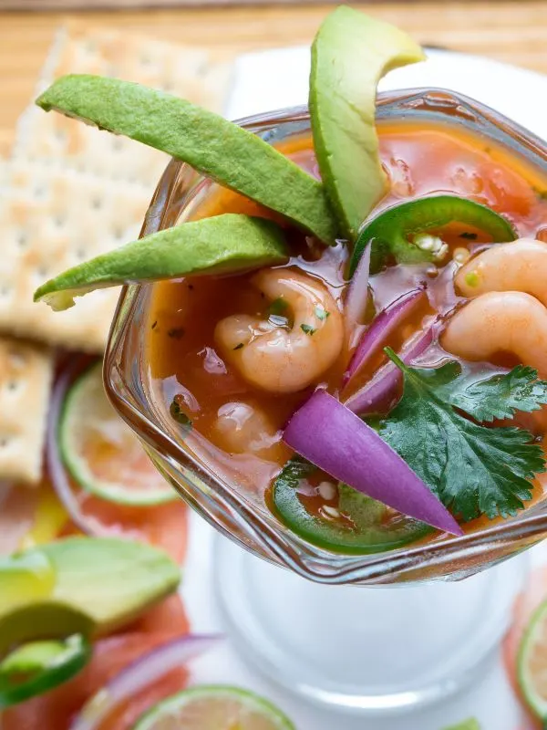 Spanish shrimp cocktail in a glass, with avocado slices and crackers. 25 Best Spanish Seafood Recipes to Try at Once!