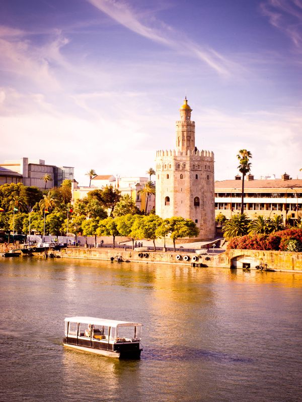a small ship on the river Guadalquivir and Torre del Oro. One Day in Seville: A Local's Itinerary for 10 Fun Things to Do