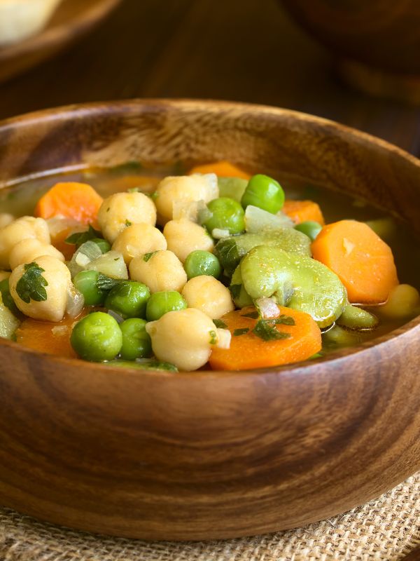 closeup with Spanish chickpea soup in a wooden bowl