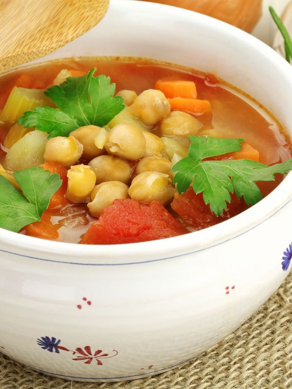 closeup with spanish soup with chickpeas in a white bowl