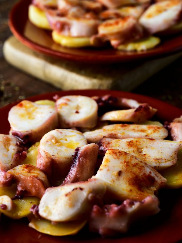 closeup with Spanish octopus recipe on a clay plate - Irresistible Spanish Octopus Recipe - Pulpo Gallego