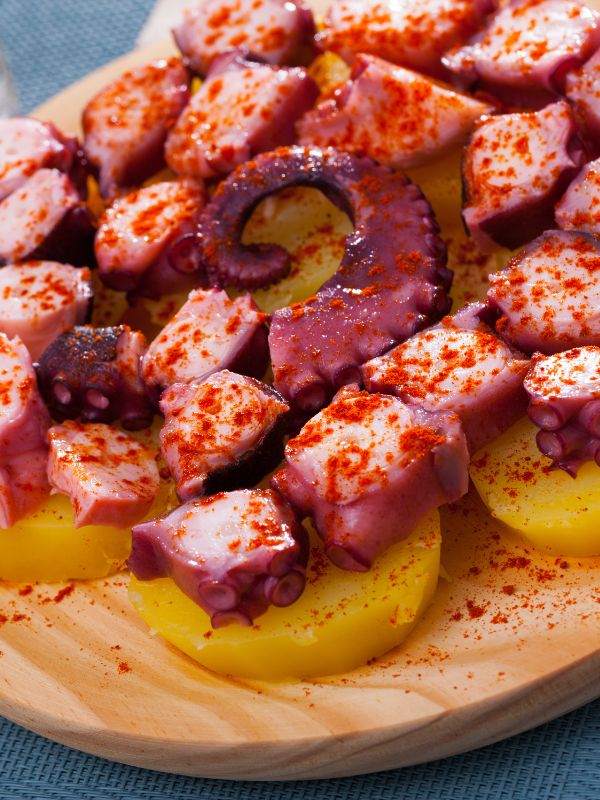 closeup with Spanish octopus, the pulpo gallego on a wooden plate