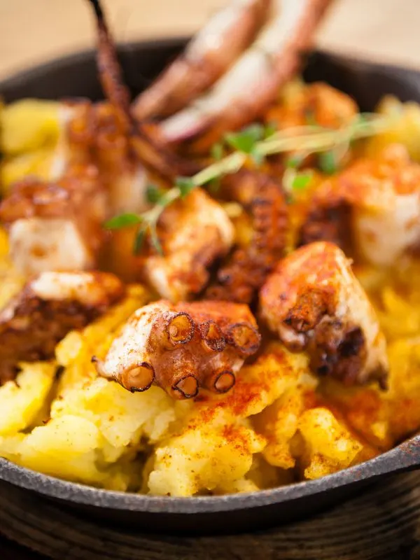 closeup with spanish octopus recipe with boiled potatoes.