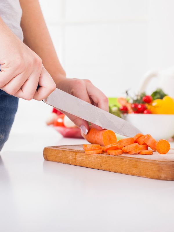 cutting vegetables on a wooden board for the spanish osso buco recipe