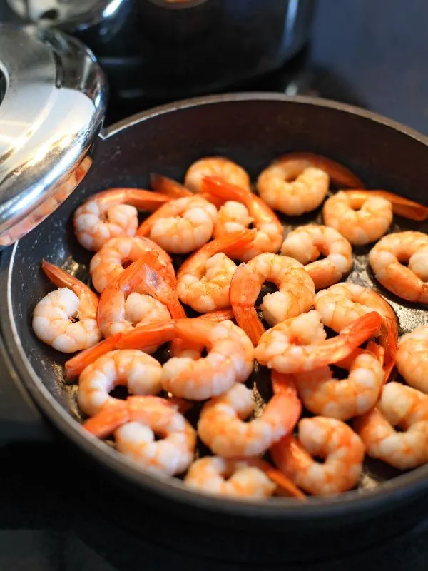 frying shrimps in a pan for the ensalada de gambas