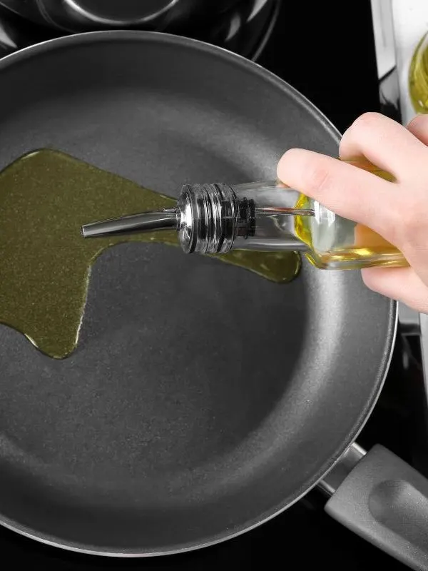 pan with oil for frying on a stove for preparing spanish sofrito recipe.
