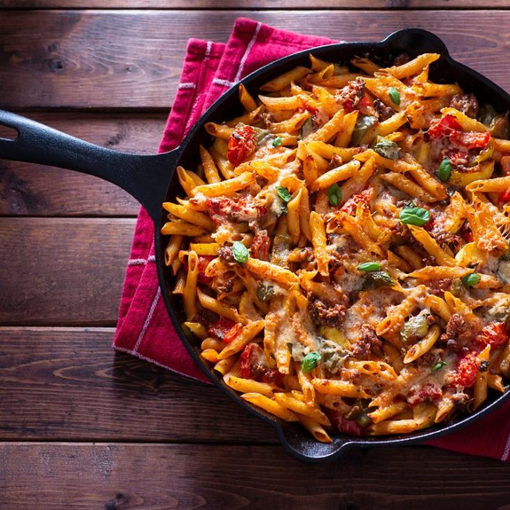 spanish chorizo pasta in a pan on a wooden table.