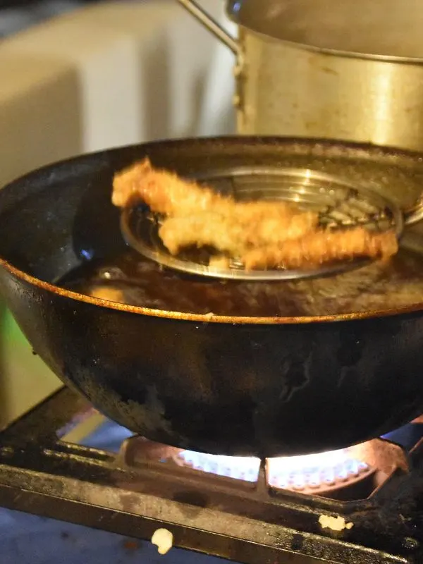 spanish fried fish being fried in oil.