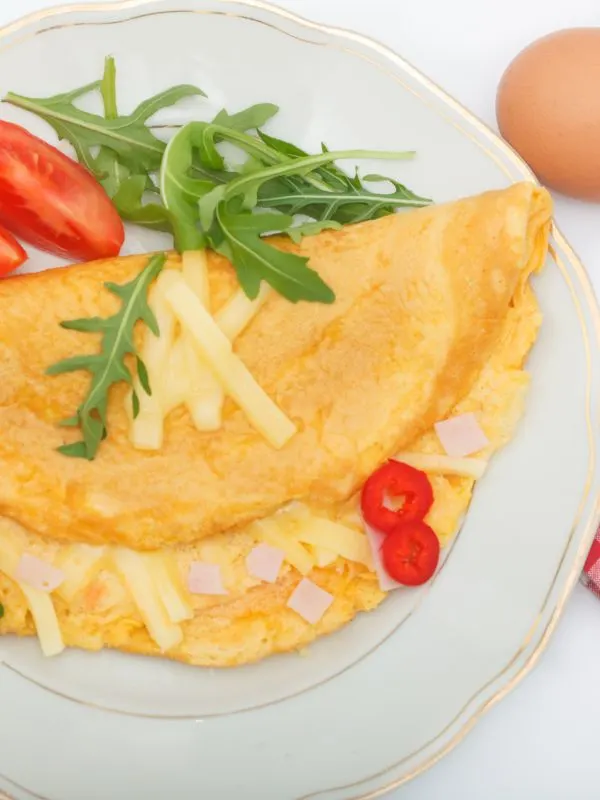spanish omelet with cheese and ham on a white plate.