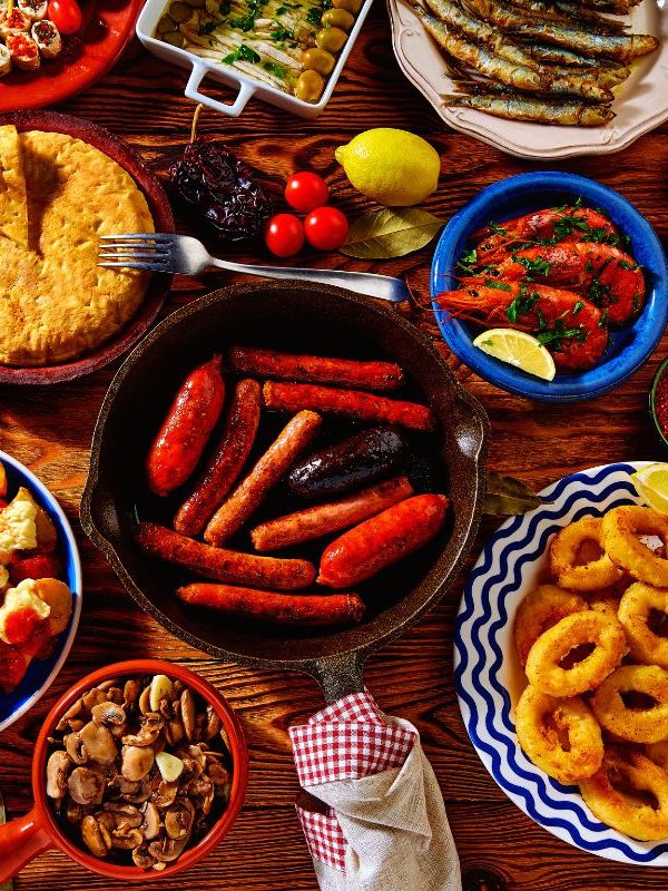 various spanish tapas plates on a wooden table