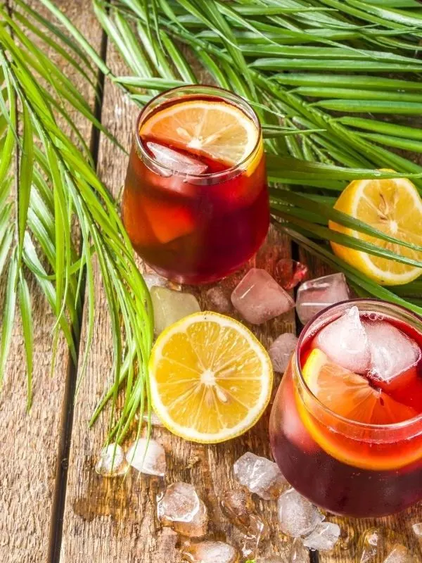 tinto de verano drink on a wooden table with oranges next to it.