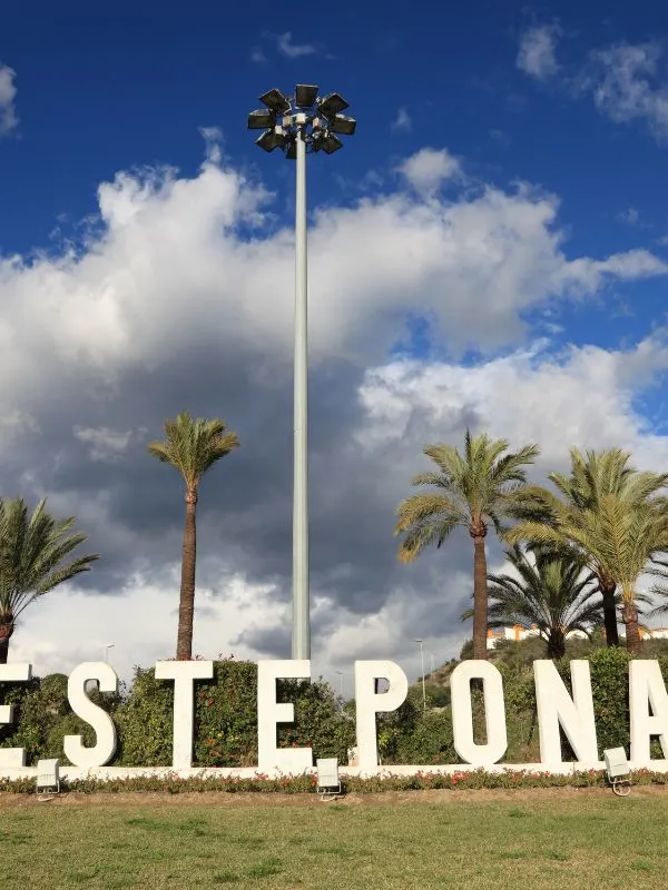 A sign of Estepona surrownded by palm trees