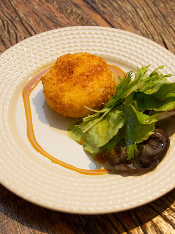 Spanish fried goad cheese with honey sauce and salad on a white plate. Sweet Fried Goat Cheese Recipe from Spain