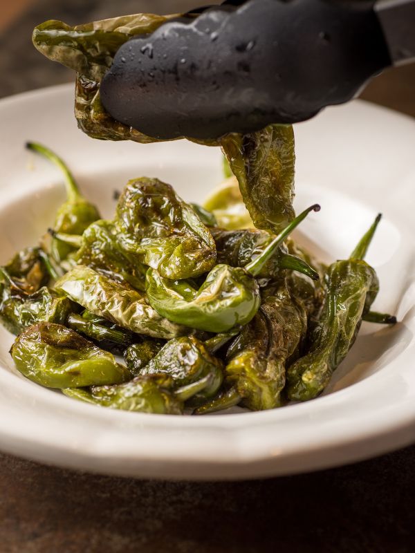 closeup with Spanish padron peppers in a white bowl